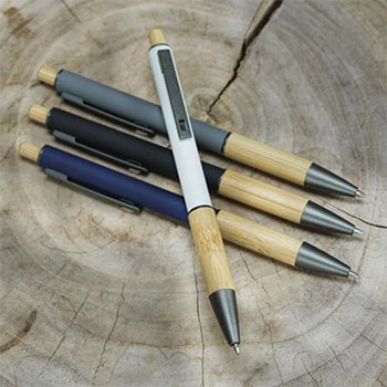 Four pens sitting on a wood stump.