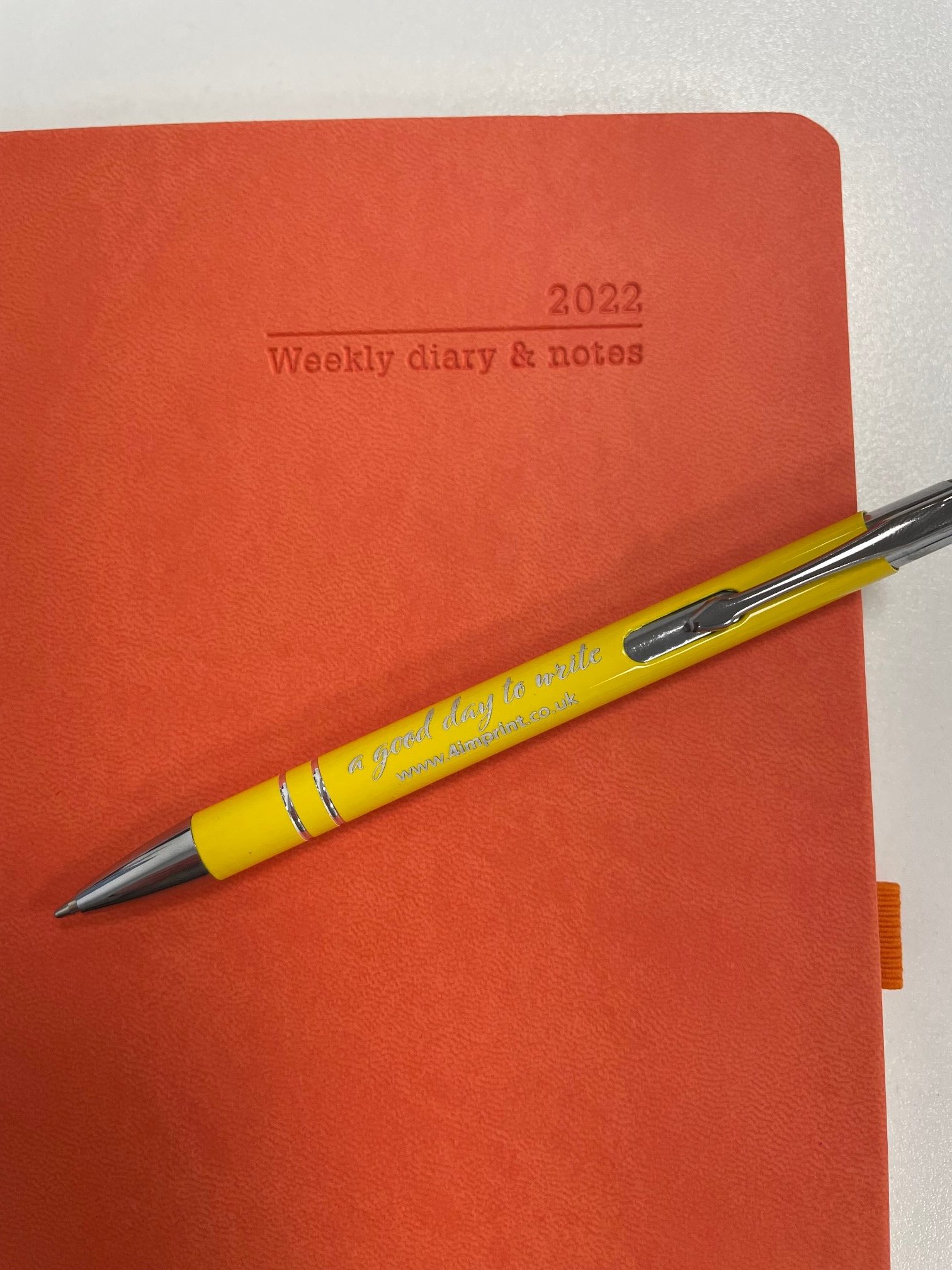 red weekly diary and notes with yellow pen on top